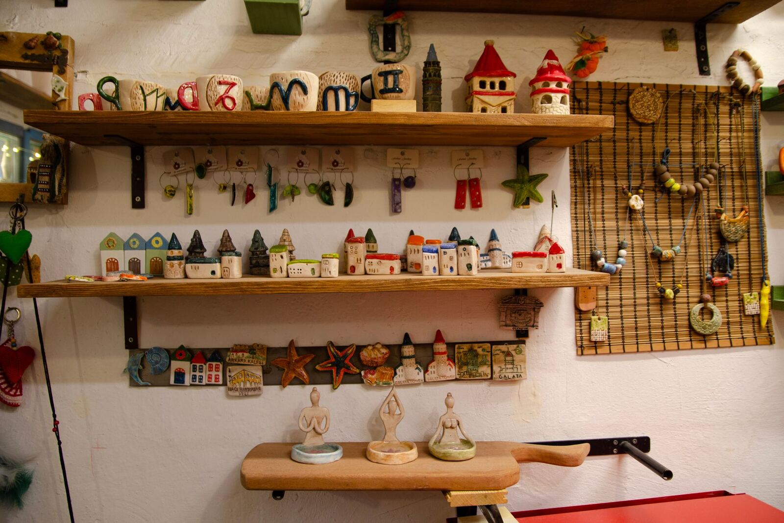 A wall shelf of small ceramic houses, mugs and figurines